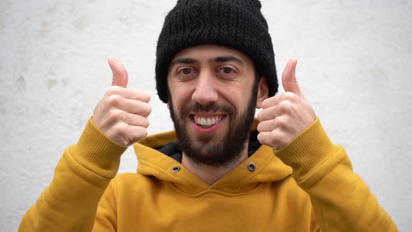 Close up Of A Man With Unshaven Face Showing A Two Hand Thumbs Up With A Smile.