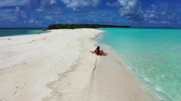 Tourists posing on tranquil resort beach time by blue ocean and white sand background of the Maldive