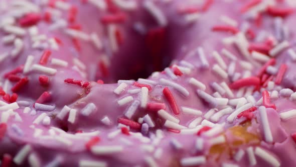 Appetizing sweet donut dessert in pink glaze close-up rotates