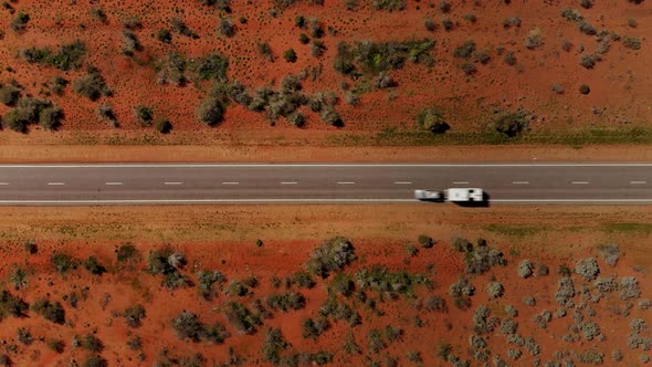 Top down aerial view of Road in the red Australian desert. Lonely Cars traveling the Outback