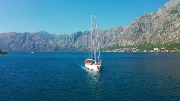 Sailing Yacht in the Bay of Kotor with Beautiful Summer Landscape of the Coastline and Mountains on