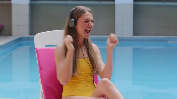 Happy European Blonde Girl Wearing Headphones Dancing Listening Favorite Song Music Podcast in Sun