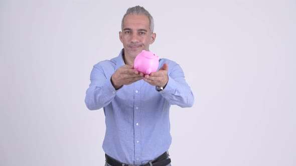 Happy Persian Businessman Giving Piggy Bank Against White Background