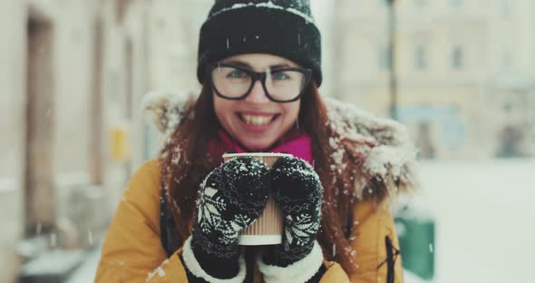 Girl in Glasses Walks around the City and Drinks Hot Coffee