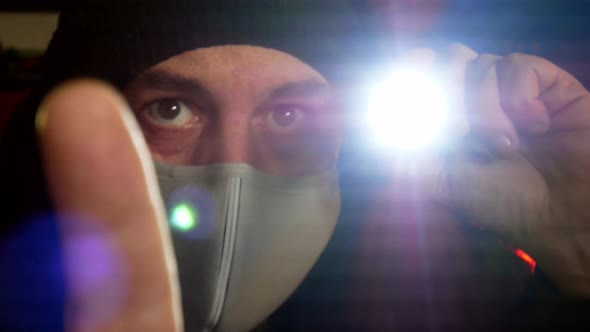 Male wearing virus mask checking worldwide contamination with torch light