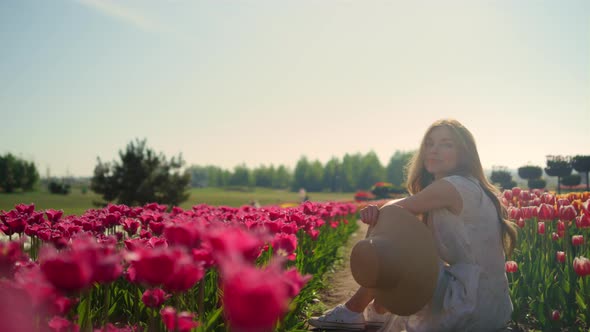 Playful Girl Flirting Among Flowers in Sunset