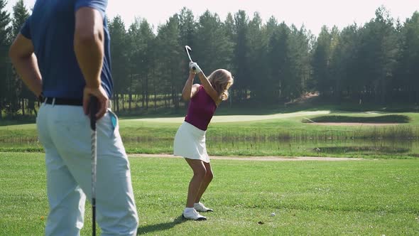 Green Park Man Trainer Teaches Woman to Play Golf Woman Hits the Ball Golf Course in Forest Area