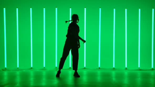 Young Woman Dancing Street Hip Hop Dance in the Studio Against the Background of Bright Neon Tubes