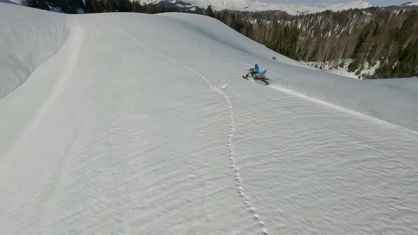 Aerial View Man Riding on Snow Bike at Winter Mountain Summit Enjoy Outdoor Extreme Sport Activity