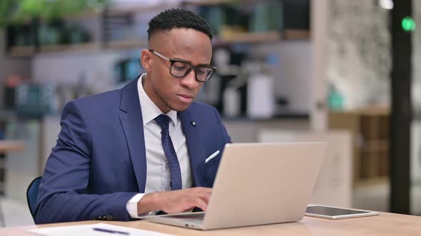 Focused African Businessman Working on Laptop in Office