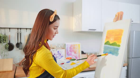 Asian young talented woman draw art picture, creating artwork with watercolor paint and brush.