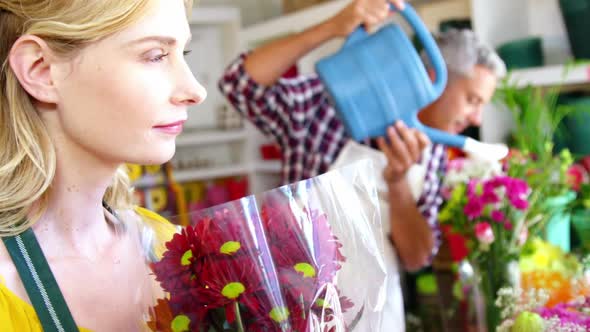 Beautiful female florist smelling bouquet of flower