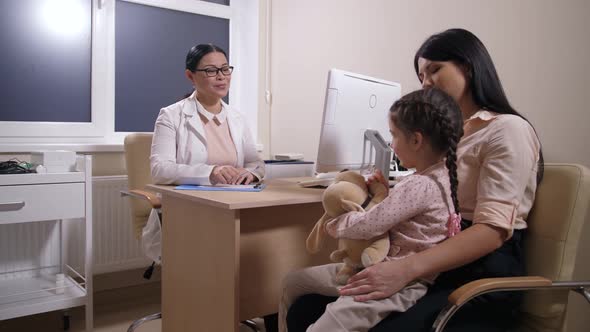 Doctor Writing Medical Prescription for Sick Child