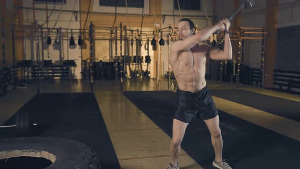 Man Hitting Tire with Sledgehammer