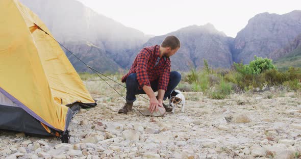 Caucasian man setting up camping tent