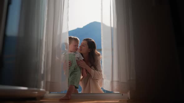 Baby Toddler Boy Kissing with Tender Mother on Balcony at Tropical Beach Resort