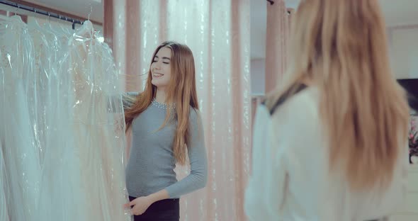 Happy Bride Is Holding a Wedding Dress and Smiling