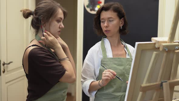 Student and Art Teacher During Painting Lesson