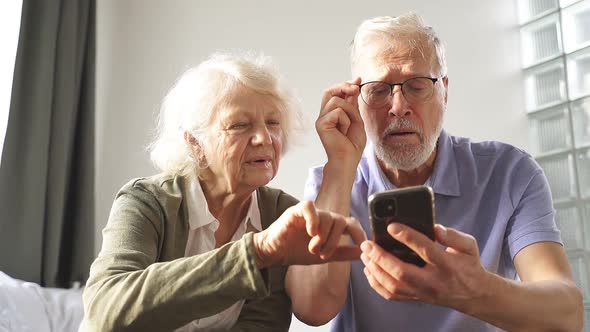 An Elderly Couple Sits at Home on a Bed and Understands Together Modern Technologies the Internet In