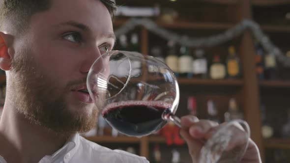 Young Handsome Man Tasting Wine in Restorount Slow Motion