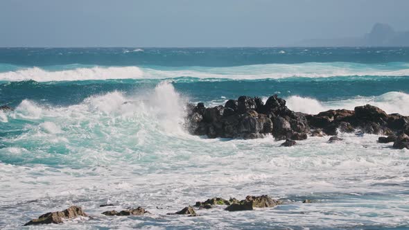 Wave Crashing in Slow Motion on Sea Rocks Rough Ocean Waters Sunny Summer Day