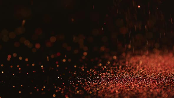 Red glitter gems spilling on black background