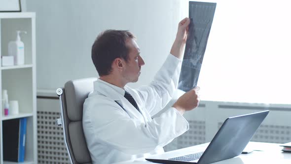 Professional medical doctor working in hospital office using computer technology.