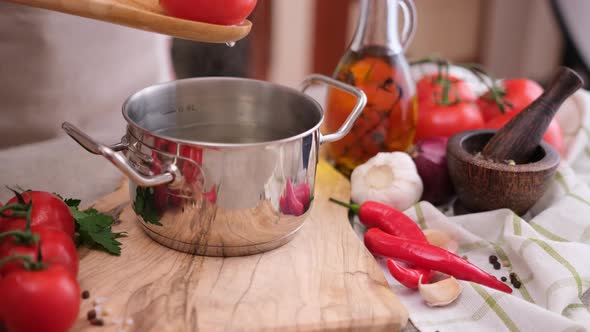 Woman Puts Tomato to Pot with Hot Boiling Water for Blanching