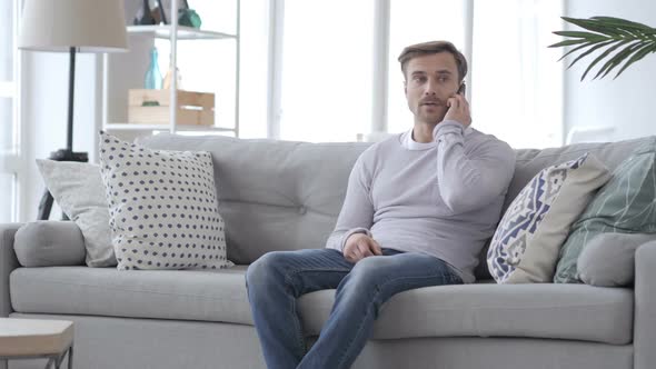 Adult Man Talking on Phone While Sitting on Couch