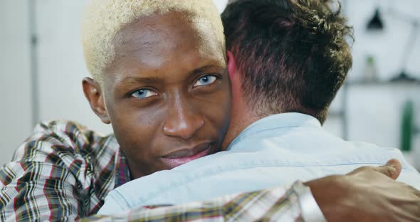 Black-Skinned Gay with Blond Hair which Tenderly Hugging His European Partner with Love
