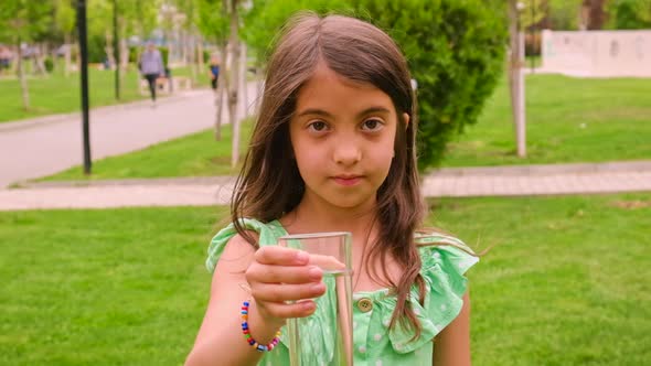 The Child Drinks Water From a Glass