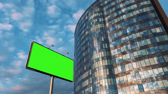 Advertising billboard green screen chroma key against a glass office modern building and a blue sky
