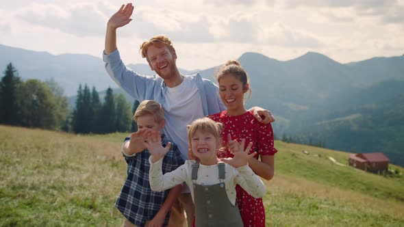Laughing Family Waving Hands Standing Mountain