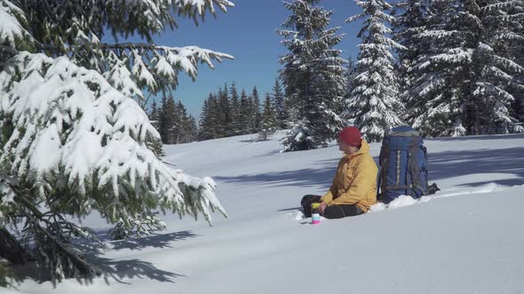 A Man Drinks Tea in a Winter Forest