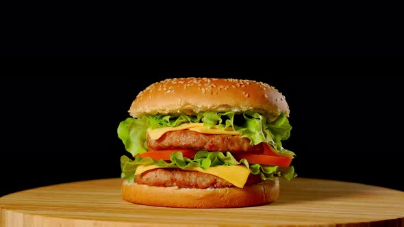 Great Burger with Beef Cutlet, Tomatoes, Mushrooms and Cucumbers with Melted Cheese Rotates on a