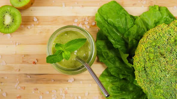 Taking Tasty Smoothie From Vegetables and Greenery with Straw Closeup