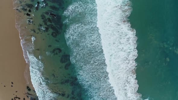 Aerial Top View on Ocean Waves and Sandy Beach