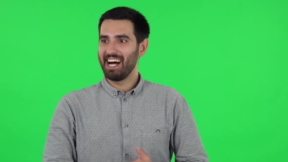 Portrait of Brunette Guy Is Waiting in Anticipation with Pleasure. Green Screen