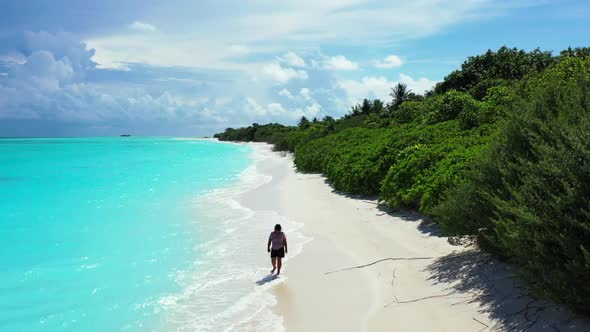 Girl relaxing on tropical island beach vacation by blue ocean and white sand background of the Maldi