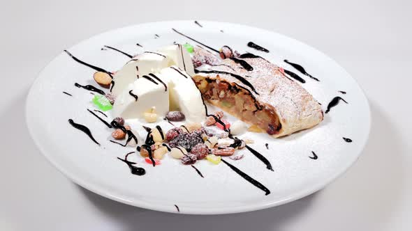 A Refreshing Dessert of Ice Cream and Sweets on a White Plate Rotates
