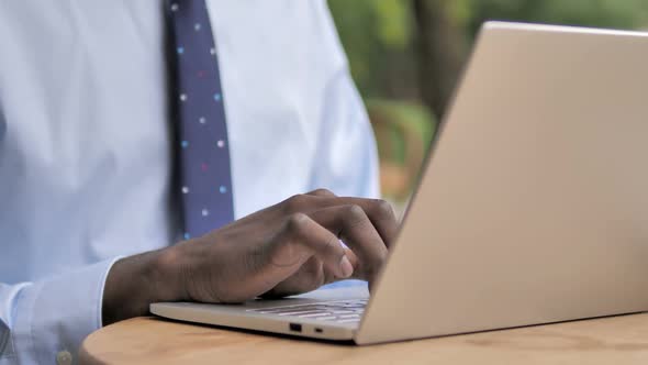 African Businessman Hands Typing on Laptop