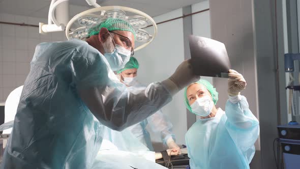 Medical Workers in Hospital Examine X-ray Prints During Operation Medicine, Surgery, Healthcare