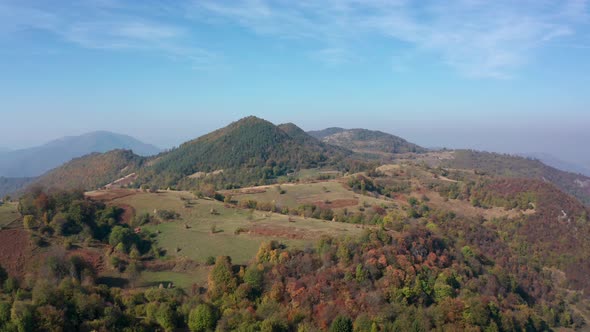 Autumn mountain with peaks, meadows and colorful forests