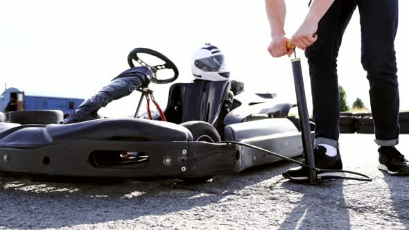 Attractive Man Checking Tire Pressure on His Gocart