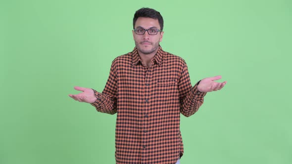 Confused Young Hispanic Hipster Man Shrugging Shoulders