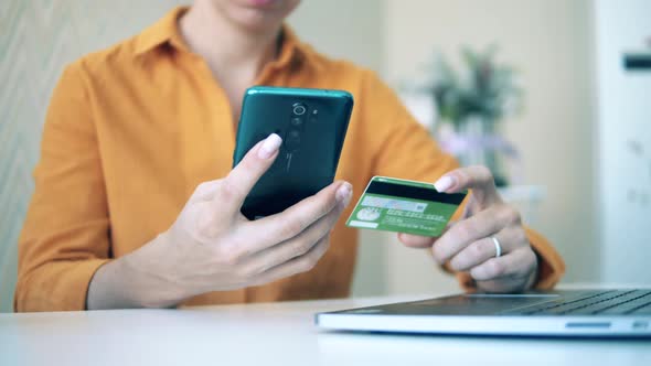 A Woman Is Using a Card and Her Smartphone for Online Shopping