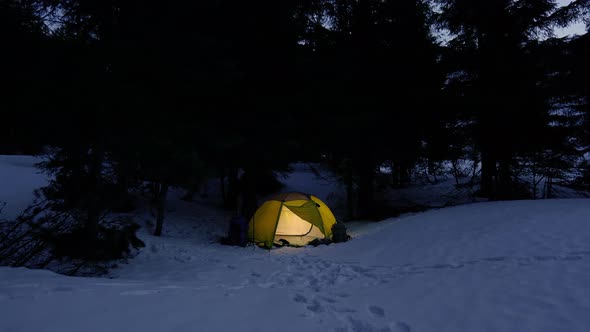 Yellow Iluminated Tent in Winter Forest