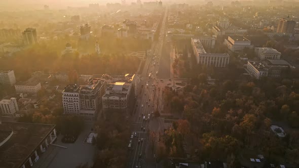 Aerial drone view of Chisinau in autumn at sunset, Moldova. Yellowed vegetation, multiple buildings,