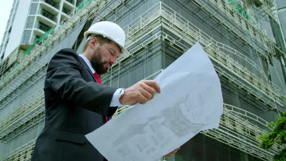 An Engineer Scientist and Developer at a Construction Site Checks on the Drawings at What Stage is