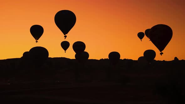 Silhouettes of Hot Air Balloons on Orange Sunset Sky Background